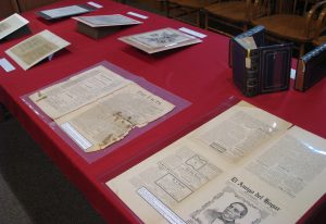 Historical materials on a table with a red tablecloth.  