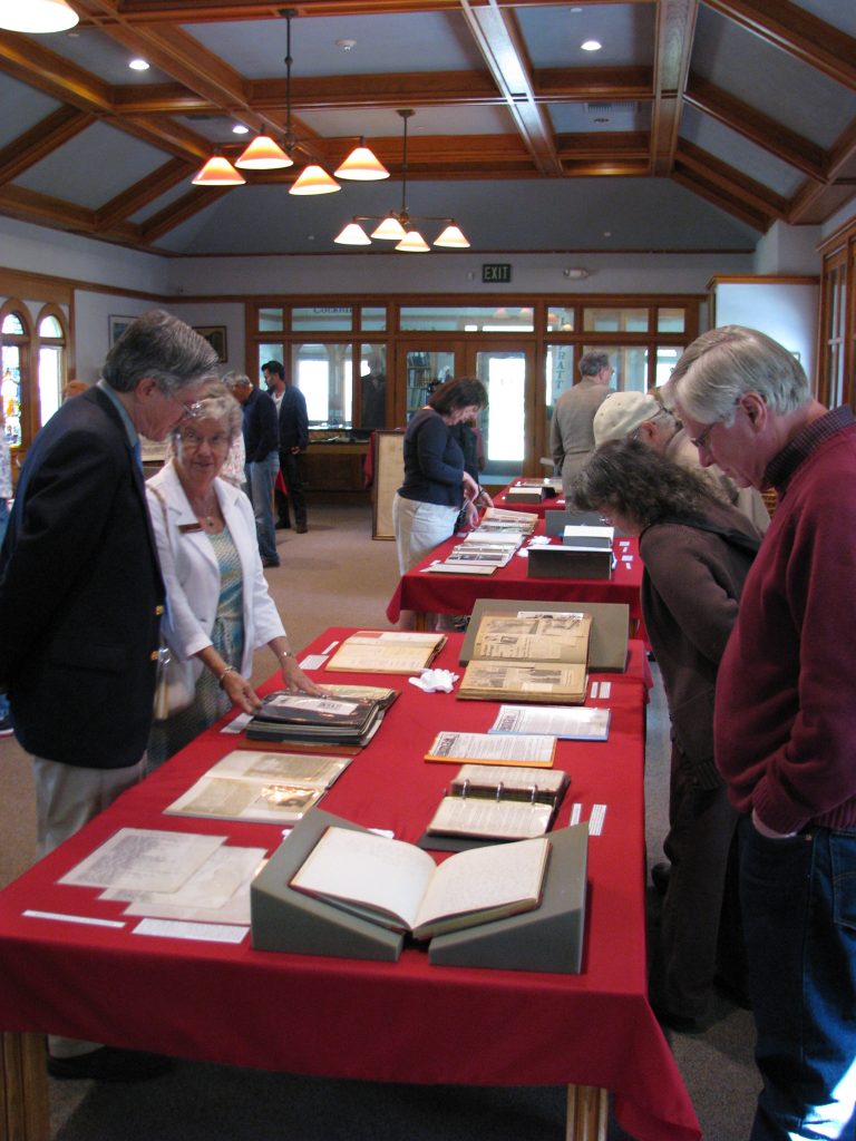 Individuals in the Heritage Room looking at historical materials placed on tables.